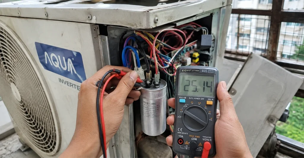 Dùng đồng hồ VOM kiểm tra tụ điện bên trong dàn nóng máy lạnh Aqua bị bám bẩn