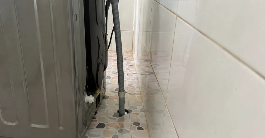 Kiểm tra và nắn thẳng ống xả nước phía sau máy giặt Midea