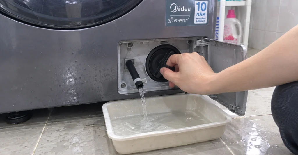 Xả nước khẩn cấp qua ống xả phụ trước khi vệ sinh bộ lọc máy giặt