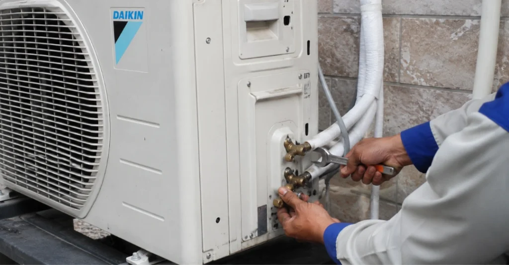 Kỹ thuật viên kiểm tra và mở hoàn toàn van gas trên cục nóng