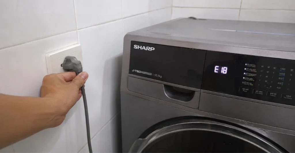 Rút phích cắm nguồn máy giặt Sharp để đảm bảo an toàn khi xử lý lỗi